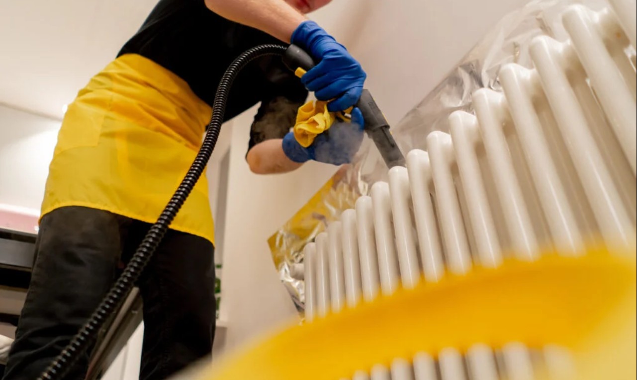 A cleaner steam cleaning fixtures during a detailed deep clean